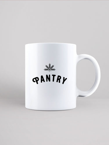 White ceramic mug that is speckled with black. Pantry logo and leaf printed in black.